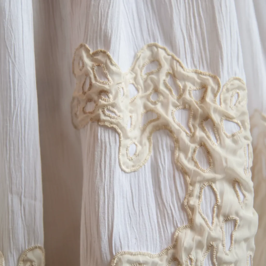 Detail of hand embroidery on white skirt